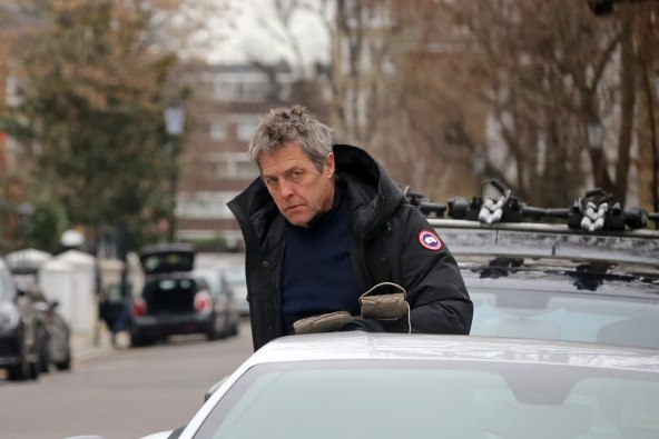 Hugh Grant sjedao je za volan srebrnog Ferrarija modela F12 u zimskoj jakni brenda Canada Goose.