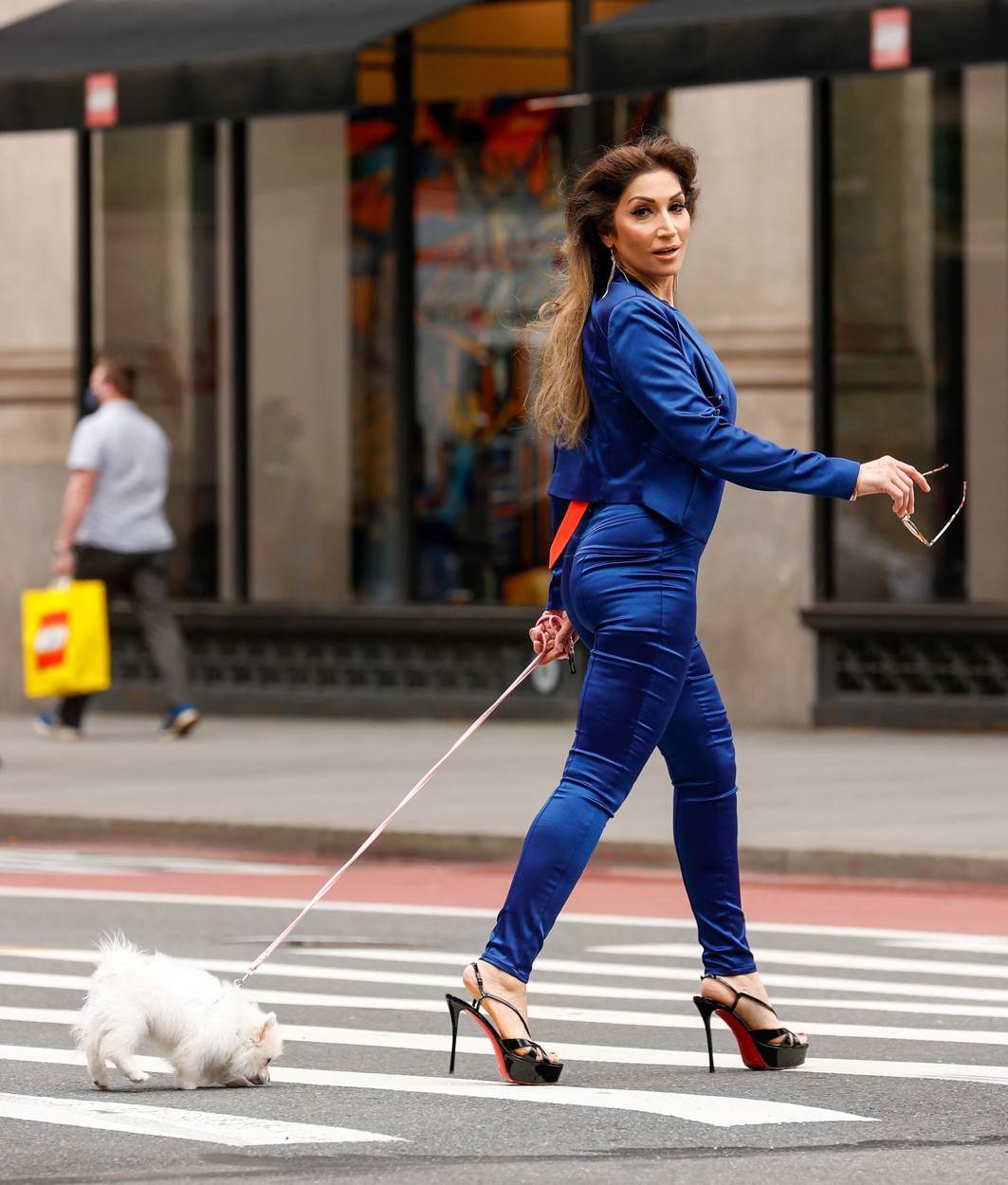 Žena u visokim potpeticama šeta psa
