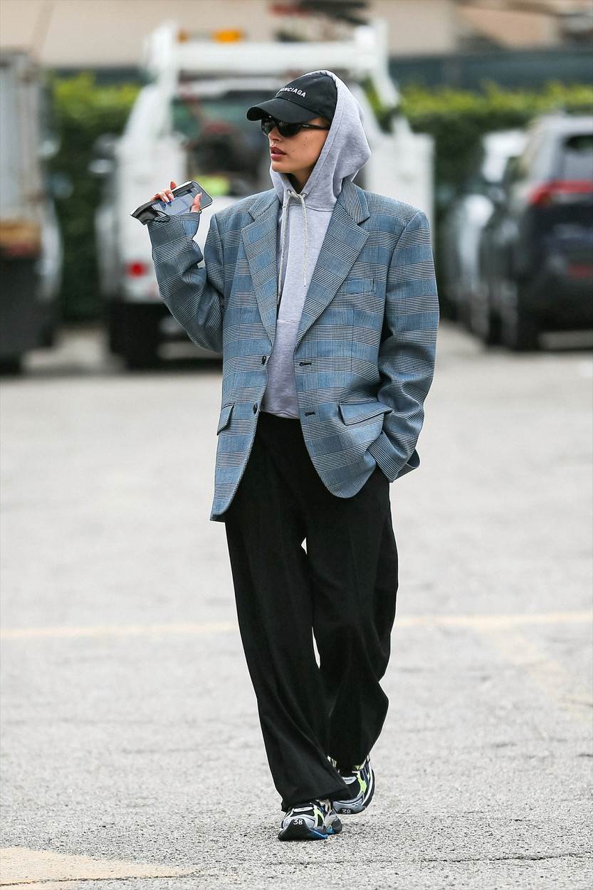 Hailey Bieber oversized karirani sako odjenula je preko sive majice s kapuljačom dok je šetala parkiralištem trgovine