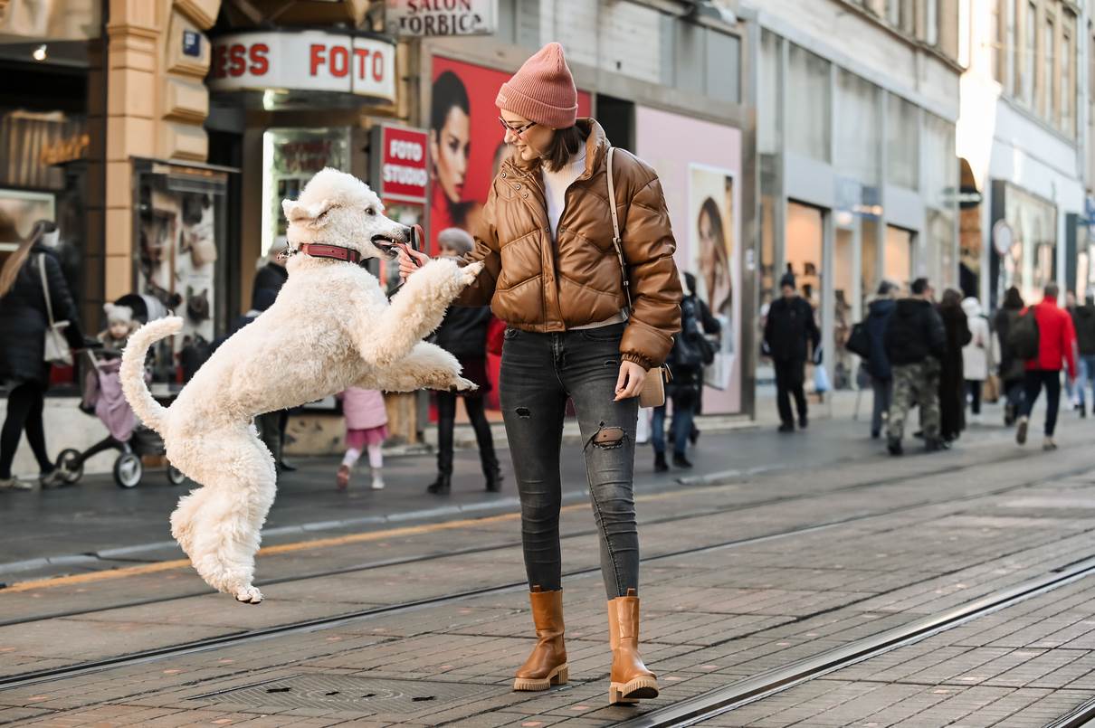 Djevojka sa psom na špici savršeno je iskombinirala Zara jaknu sa smeđim visokim čizmama