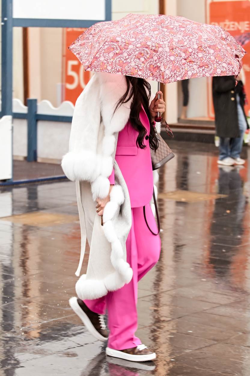 Djevojka na špici vješto je skrivala lice ispod kišobrana