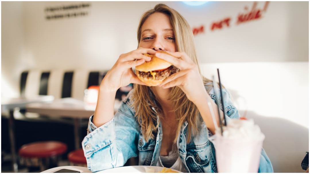žena jede hamburger