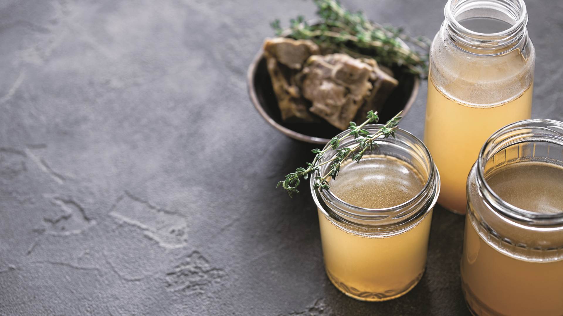 stock-photo-glass-jar-with-yellow-fresh-bone-broth-on-dark-gray-background-healthy-low-calories-food-is-rich-1783821884.jpg