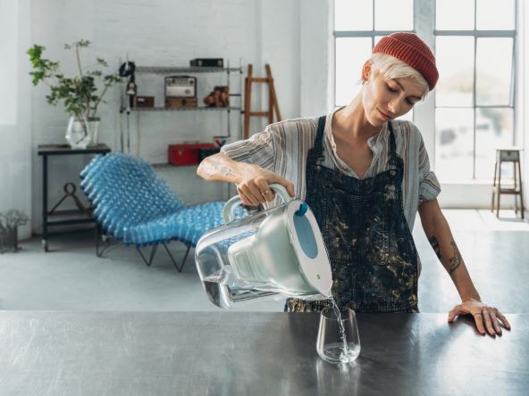 2023_Turn_on_the_taste_campaign_chair_montaža Style_Jug_XL_grey_Lifestyle_loft_workshop_product_in_use_woman_pouring_water.jpg