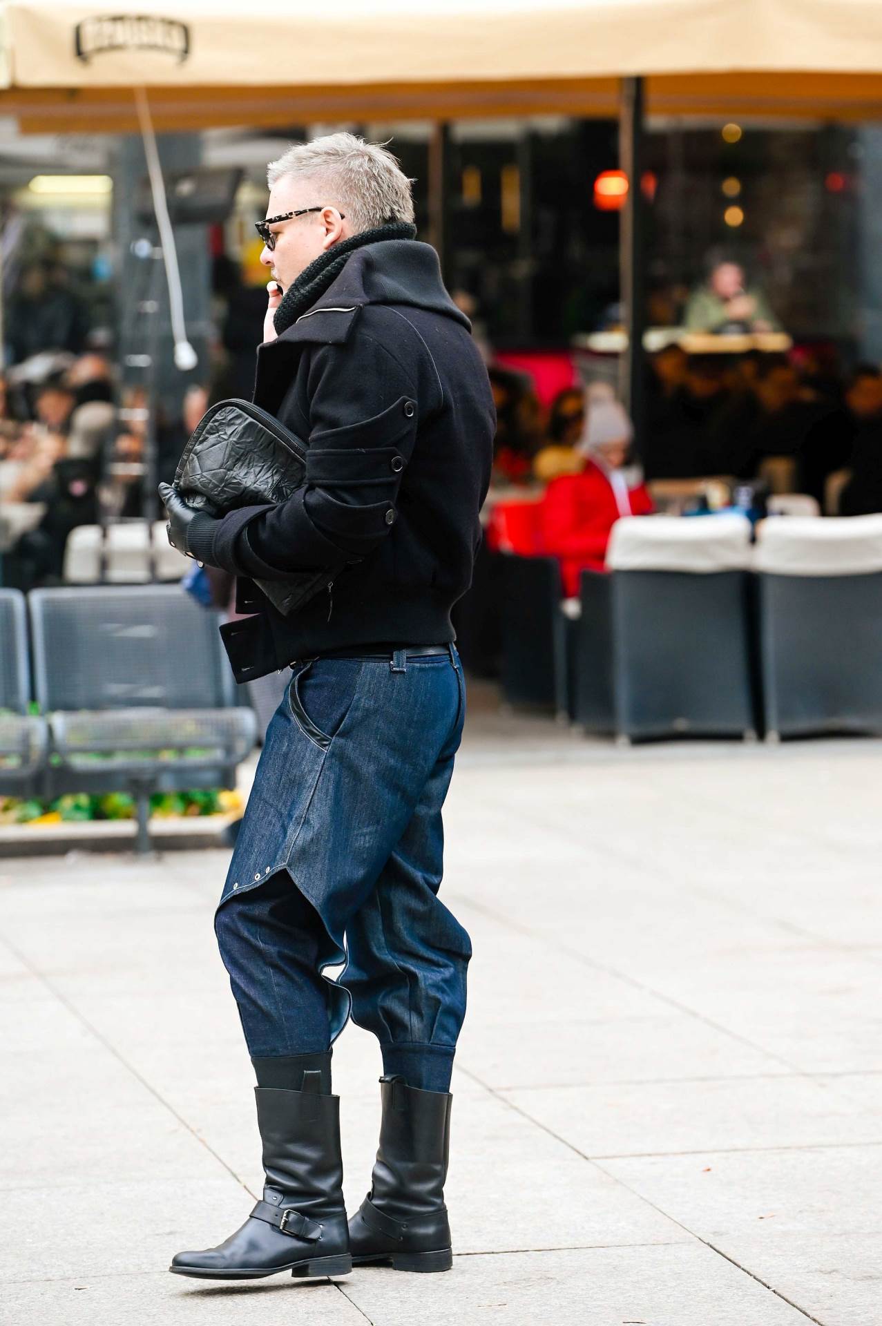 Plavuša na špici u maslinastom kaputu s upadljivim detaljima