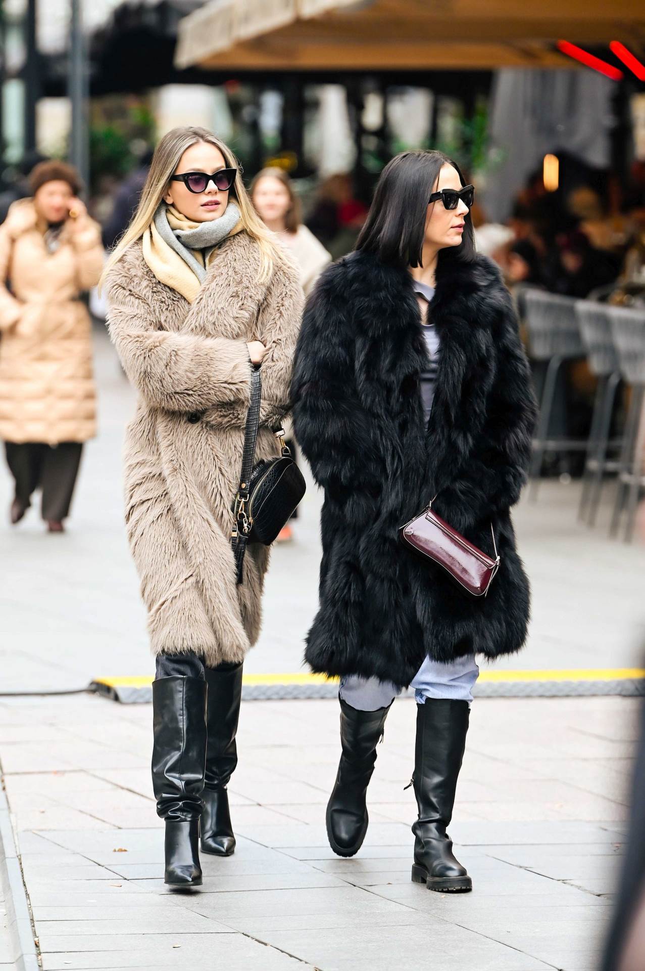 Plavuša na špici u maslinastom kaputu s upadljivim detaljima