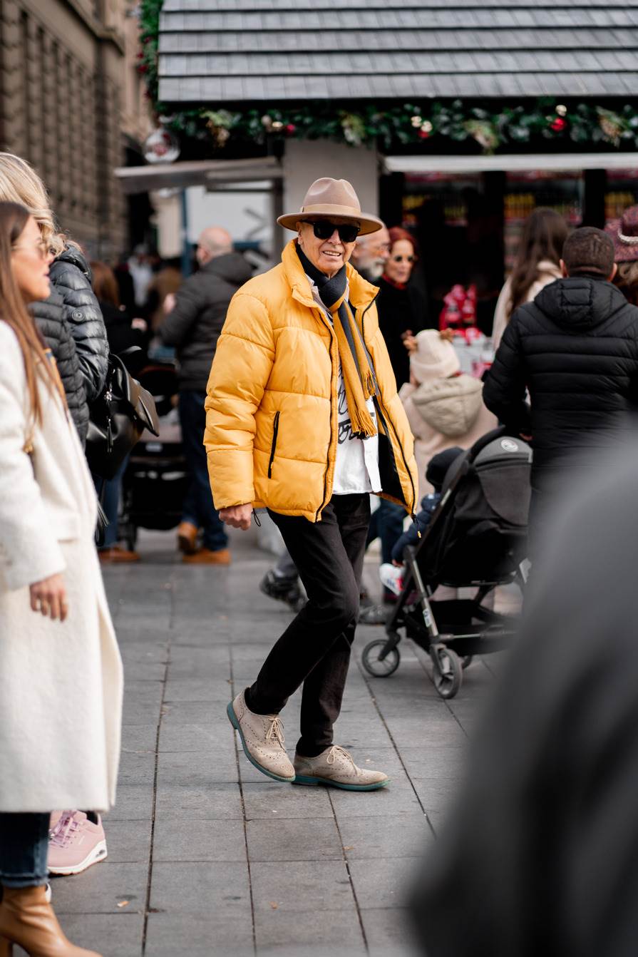 Stylish muškarac u žutoj puffer jakni na špici